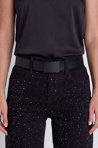 The Bianca Belt in noir worn at the waist, showing the black leather and matte black buckle