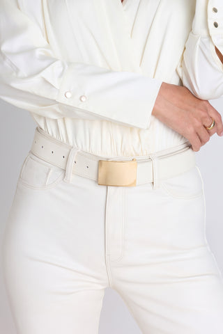 The Bianca Belt in pearl worn at the waist, showing the minimalist gold buckle