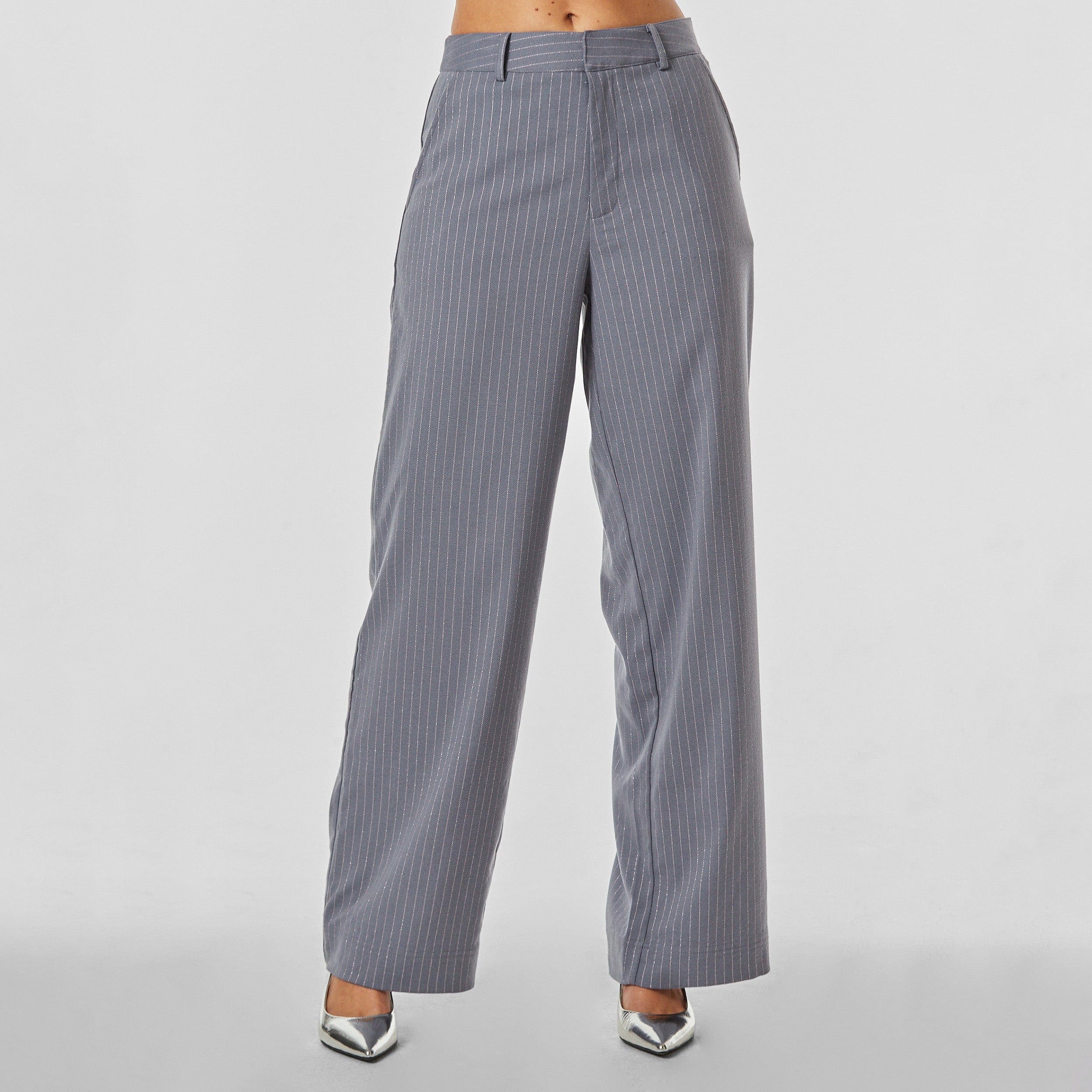 Front view of woman wearing silver pinstripe on grey trouser with oversized fit