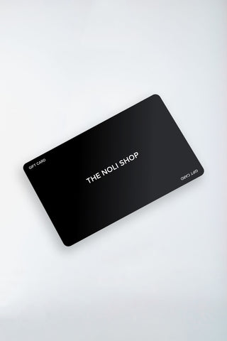 A black NOLI SHOP gift card with crisp white letters on a light gray background features rounded corners and "GIFT CARD" in smaller text, offering an elegant choice for any shopping adventure.
